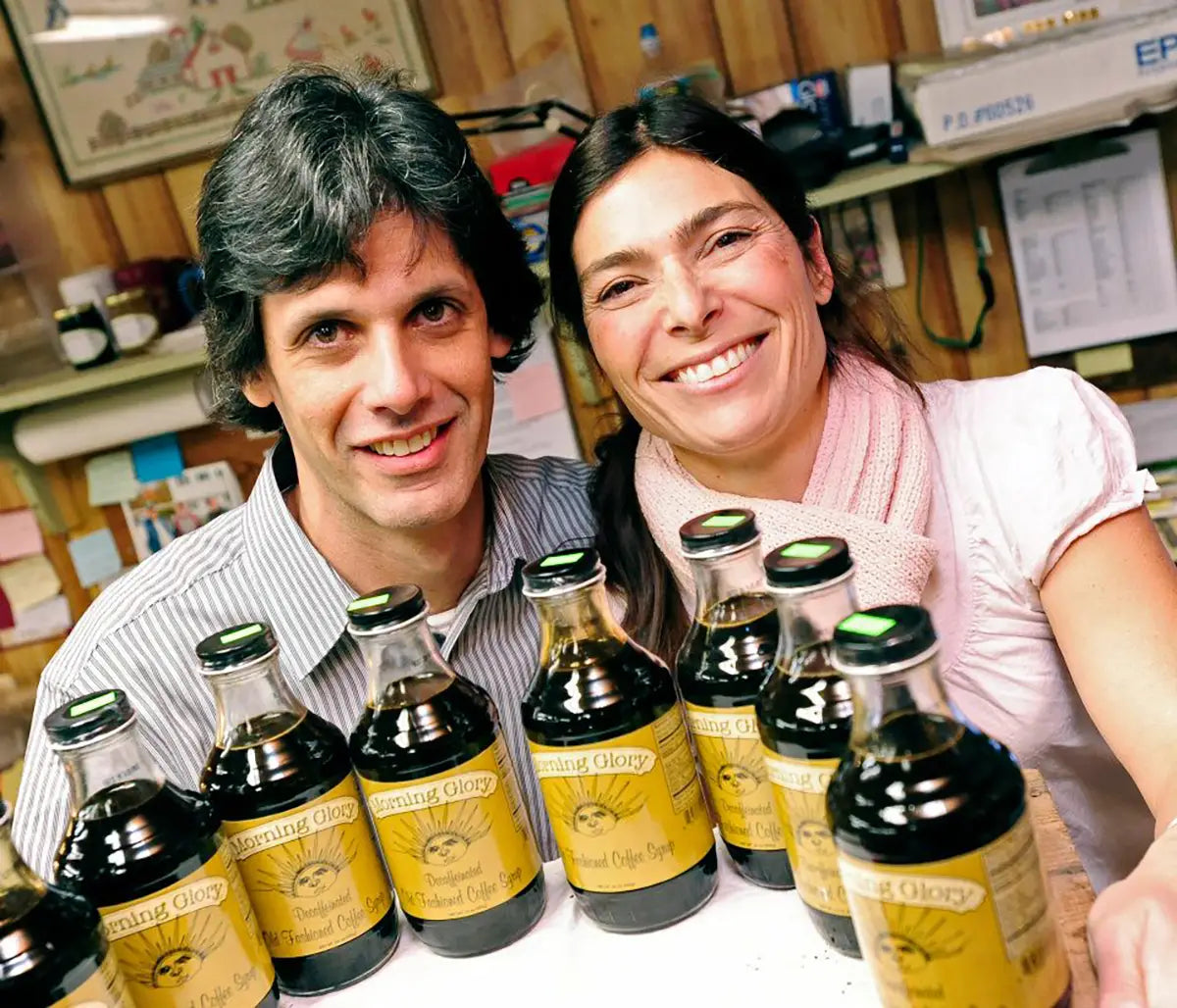 Two people with bottles of Morning Glory product on a table in a kitchen setting